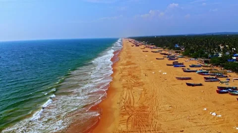 Smooth drone glide along expansive sandy beach with repeating wave patterns and Stock Footage 325842403