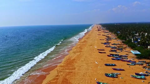 Smooth drone glide along expansive sandy beach with repeating wave patterns and Stock Footage 325842409