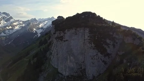 Smooth Drone shot of Alpine Cliff and Snowy Peaks in Switzerland Stock Footage 122212866