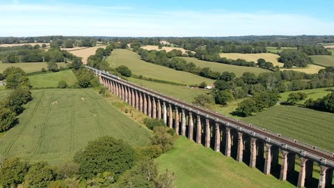 Smooth Drone Shot of Commuter Train crossing Victorian Viaduct in Sussex, Stock Footage 116715122