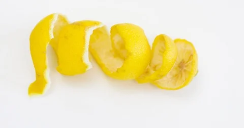 Smooth entry into the frame of a lemon rind which is twisted in a spiral Stock Footage 118709017