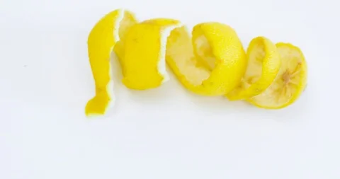Smooth exit from the frame of a lemon rind which is twisted in a spiral Video stock 118709009