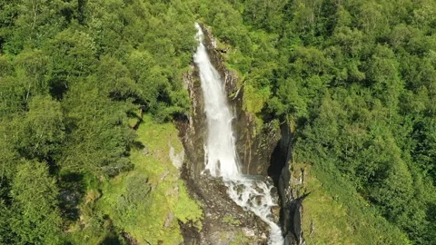 Smooth flight along large waterfall in the middle of the forest on a sunny Stock Footage 269298334