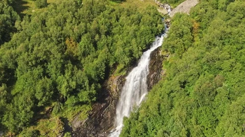 Smooth flight along large waterfall in the middle of the forest on a sunny Stock Footage 269299758