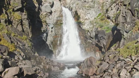 Smooth flight and ascent between the rocks to the waterfall above the river on a Stock Footage 264093133