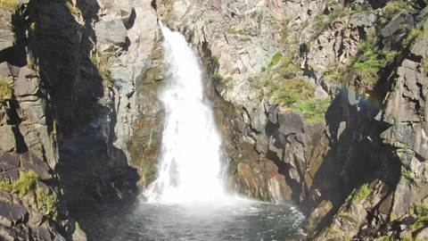 Smooth flight and ascent between the rocks to the waterfall above the river on a Stock Footage 269303343