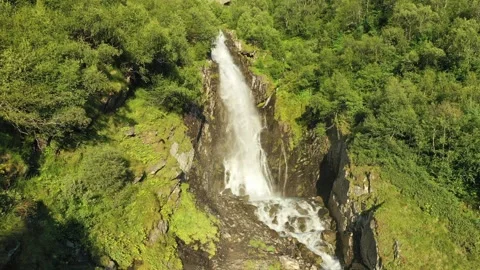 A smooth flight back from the foot of a large waterfall in the middle of the Stock Footage 269298887