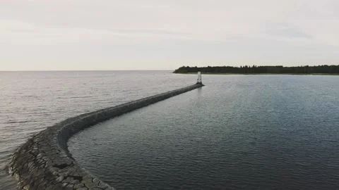Smooth flight back over the lake, a long stone path to a small lighthouse Vidéo 161433855