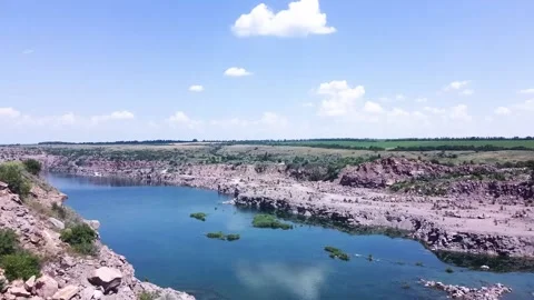Smooth flight of the drone towards the flooded granite stone quarry. Aerial shot Stock Footage 134237706