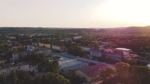 Smooth flight forward on a drone over an evening small town, sunset Vidéo 161824421