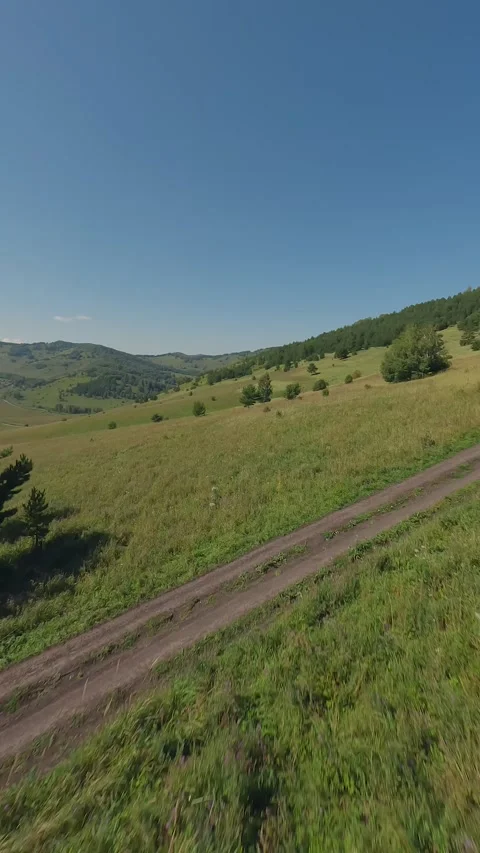 Smooth flight an FPV drone in a hilly area during a sunny summer day Stock Footage 283542344