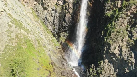Smooth flight in the mountains above the waterfall. A powerful stream breaks Stock Footage 277191452