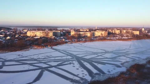 Smooth flight over a frozen river, small houses in the distance Vidéo 152831968
