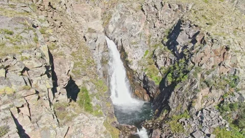 A smooth flight of the waterfall in a bowl between the rocks on a sunny day. Stock Footage 269302422