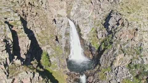 A smooth flight of the waterfall in a bowl between the rocks on a sunny day. Stock Footage 269302846
