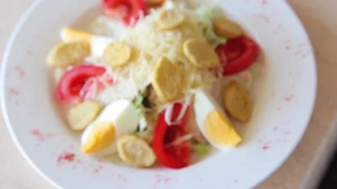 Smooth focus from bokeh to salad with eggs, tomatoes and grated cheese Stock Footage 154388920