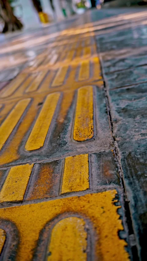 Smooth forward tracking camera movement over tactile paving blocks and yell.. Stock Footage 342036709