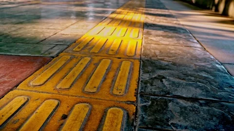 Smooth forward tracking camera movement over tactile paving tiles and yello.. Stock Footage 342037114