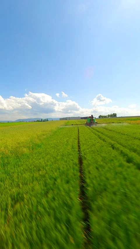 Smooth FPV flight behind a tractor spraying an agricultural field. Stock Footage 280221743
