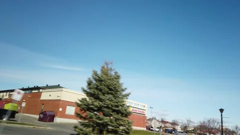 Smooth Gimbal Driving Tracking Shot of Jean Coutu Pharmacy Stock Footage 224779523