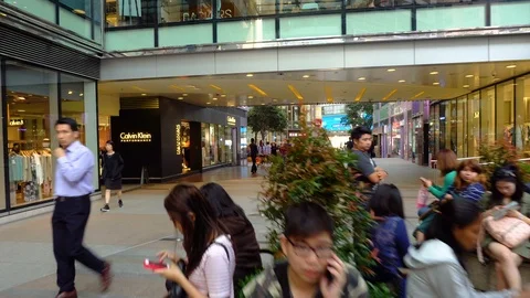 Smooth gimbal motion walking through busy city with people sitting Stock Footage 92043923
