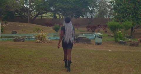 Smooth gimbal tracking shot circling a dark-skinned girl in a bold leather Видео 336649937