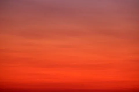 A smooth gradient sky with warm red, orange, and purple tones at sunset, idea Stock Photos