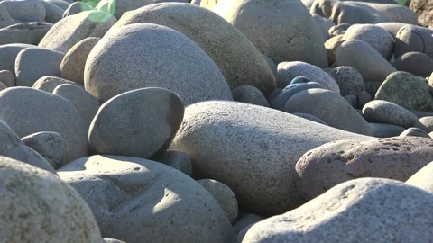 Smooth gray pebbles and rounded stones create a clean texture in macro closeup Stock Footage 339479603