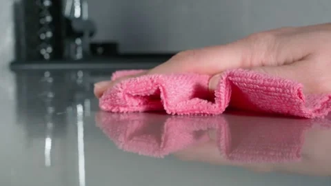 The smooth gray table surface is hand wiped with a pink microfiber cloth Stock Footage 149232252