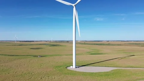 Smooth left-to-right aerial pan of a modern wind turbine generating power. Stock Footage 316638625