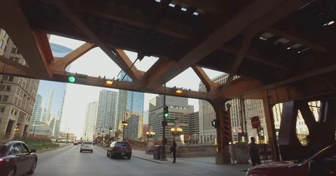 Smooth, low angle tracking shot, taken from a car, as it rides down the Chicago Stock Footage 81880718
