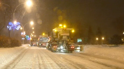 Smooth motion shot of snow clearing trucks driving ahead in winter in city Stock Footage 101218008