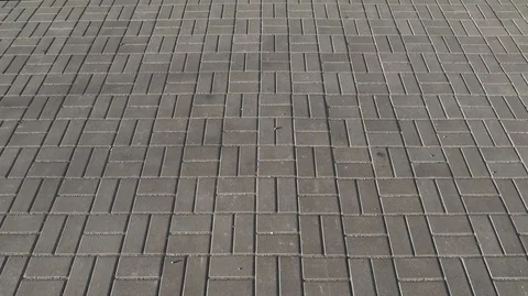 Smooth movement of the camera along the paving slabs of gray, rectangular shape Stock Footage 126353173
