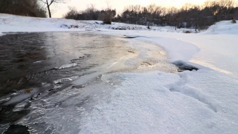 Smooth movement upstream on the edge of the ice as the sun sets. Stock Footage 120488783
