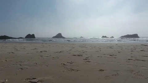 Smooth moving shot along sandy beach with footprints Video stock 70591636