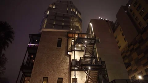 A smooth moving shot of glowing building in the foggy night sky. Stock Footage 301304621
