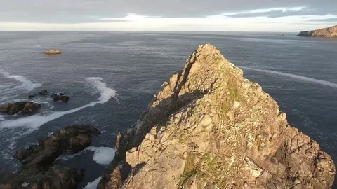 Smooth moving shot of large rock formation as bird's fly by on the ocean Video stock 70591227