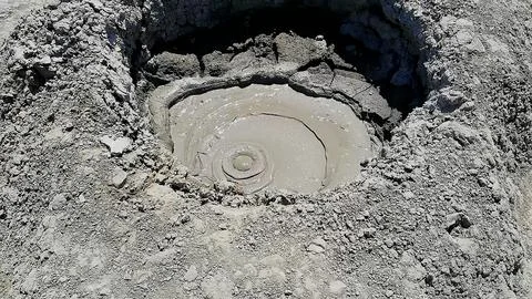 Smooth mud bubble rising in an active volcano crater Stock Photos