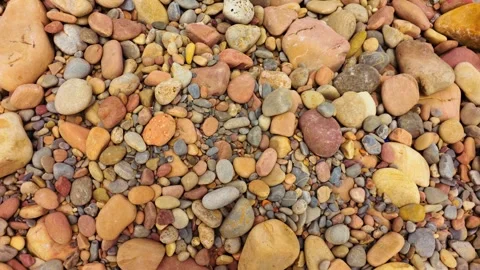 Smooth multicolored beach pebbles in close top view with red, yellow, gray and Stock Footage 341952449