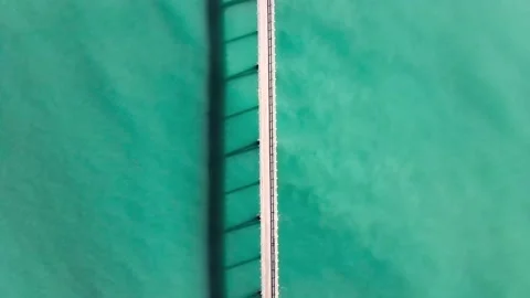 Smooth overhead drone shot over a narrow pier in Southern California Stock Footage 135702511