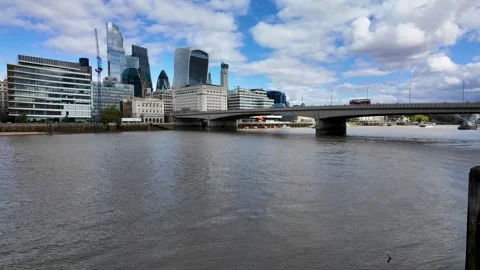 Smooth pan across River Thames toward City of London skyline and bridge Stock Footage 346677215
