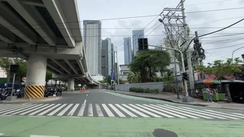 Smooth pan shot of local motorbikes and skyscrapers in Taguig 4K Stock Footage 337951032