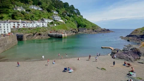 Smooth panoramic sweep across harbour beach and coastline in Polperro Cornwall Stock Footage 336033837