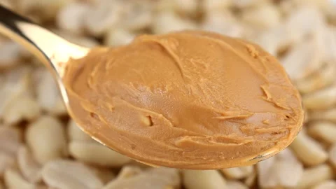 Smooth peanut butter in a spoon with peanuts circle rotation Stock Footage 274437070