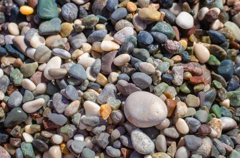 Smooth round pebbles texture background. Pebble sea beach close-up, dark wet  Stock Photos