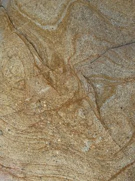 Smooth Sandstone Surface with Golden Ochre Swirl Patterns and Fissure Lines Foto stock