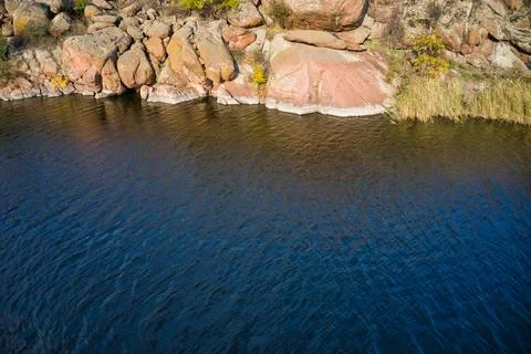 A smooth shining stream flows among large boulders Stock-Fotos