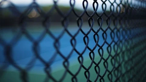 A smooth shot from outside the fence looking in on an empty tennis court. Stock Footage