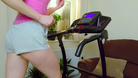 Smooth slow motion jogging of unrecognizable woman exercising on treadmill in Stock Footage 340905423