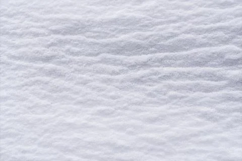 Smooth snow surface forms soft wavy texture creating calm winter background Fotos de archivo